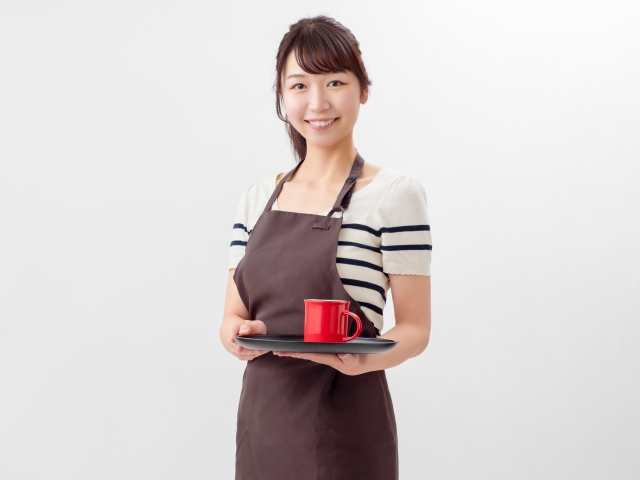 にっこり笑うカフェ店員の女性