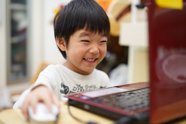 パソコンを操作するTシャツ姿の男の子